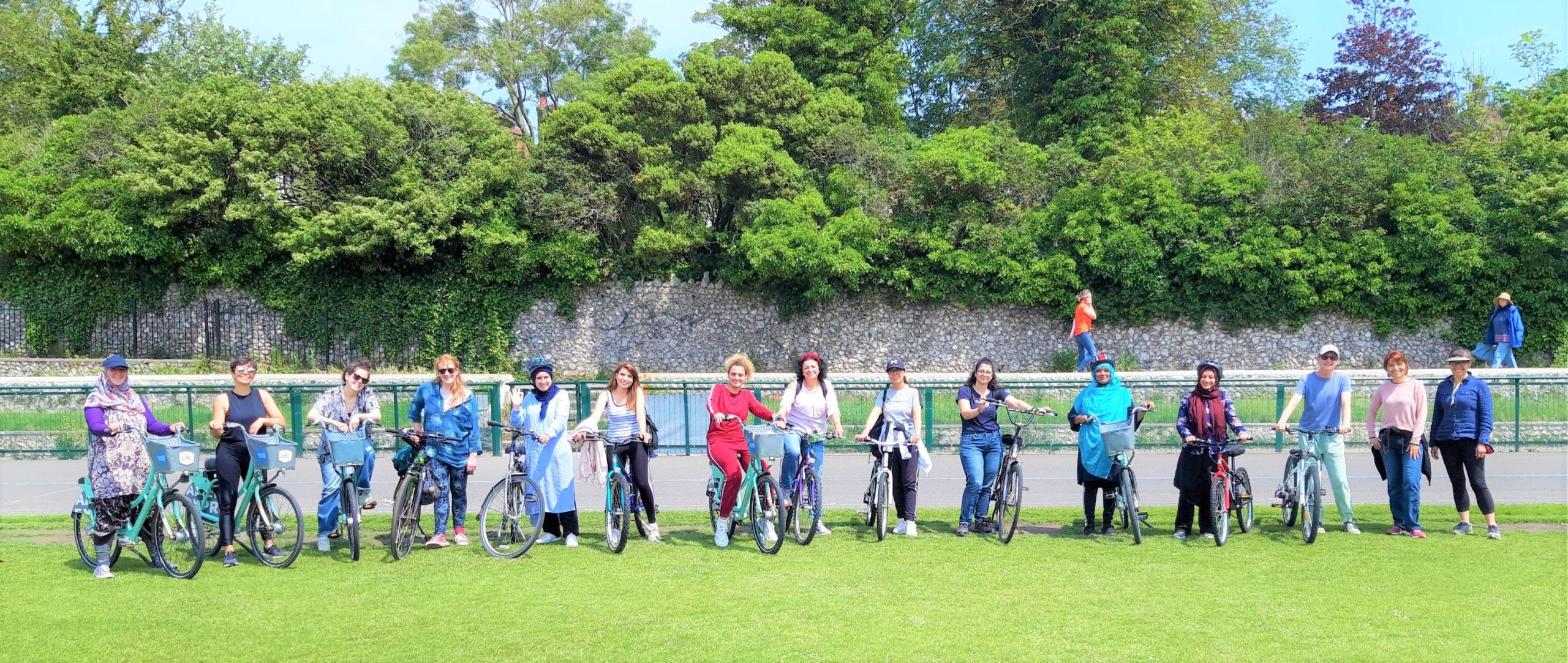 A group of women pose with bicycles in Preston Park.